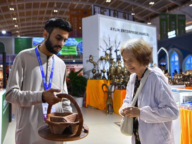 A Pakistani trader showing carpets to visitors at the South Asia Pavilion during the China-South Asia Expo 2024 held in Kunming, southwest China's Yunnan Province 4